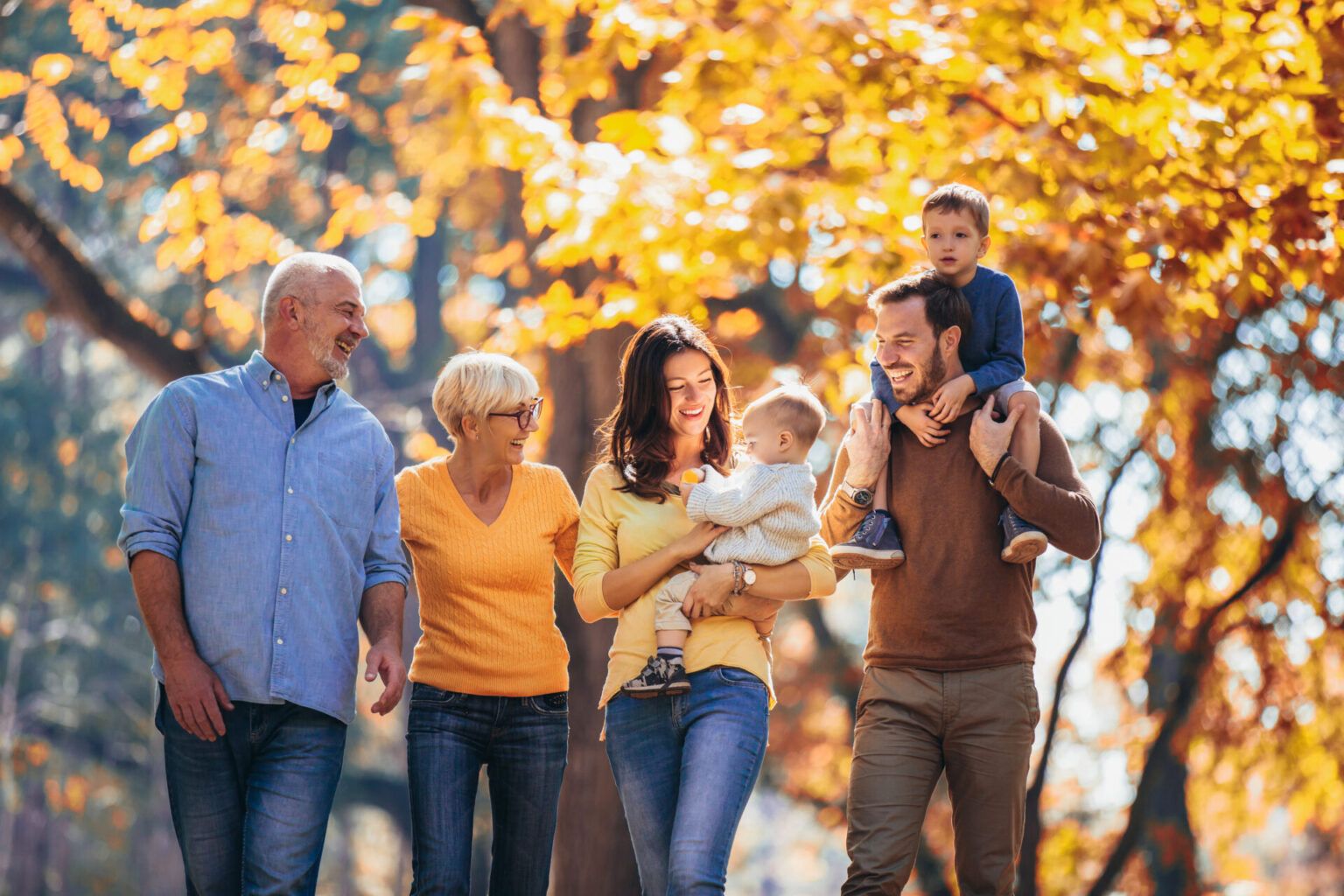 Multl generation family in autumn park having fun family therapy Reno, NV. Photo depicts a family who participated in family therapy