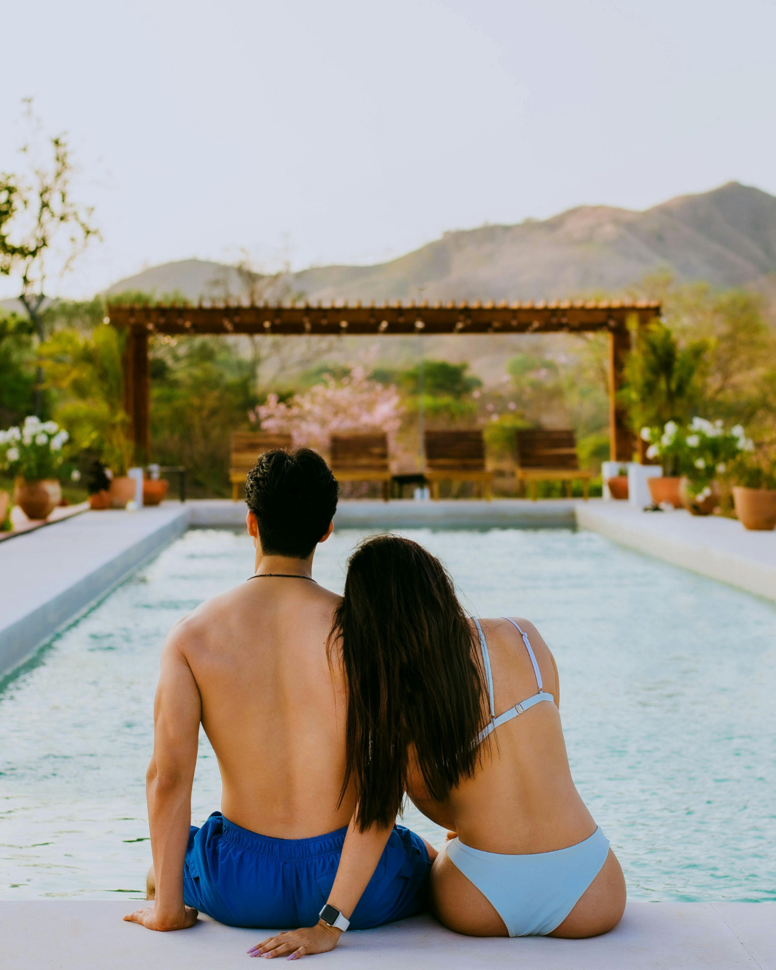 A couple sitting by a pool